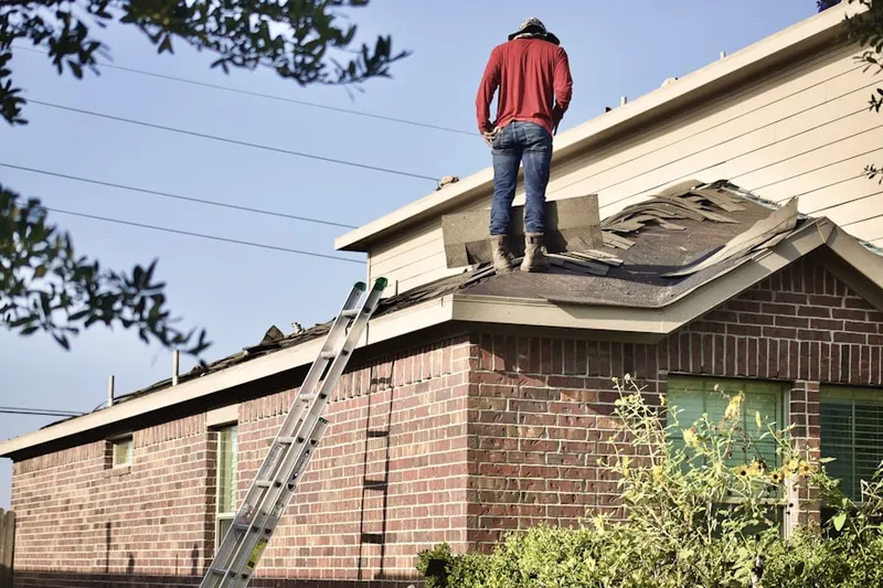 Professional roofer working on a residential roof in Neosho